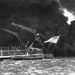 A U.S. flag flies from the stern of the sunken battleship USS We