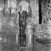 A detail shot of a light fixture flanked by two devote monks.